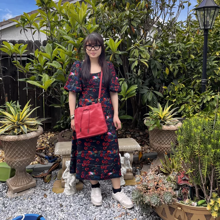 Woman with red purse in floral print maxi