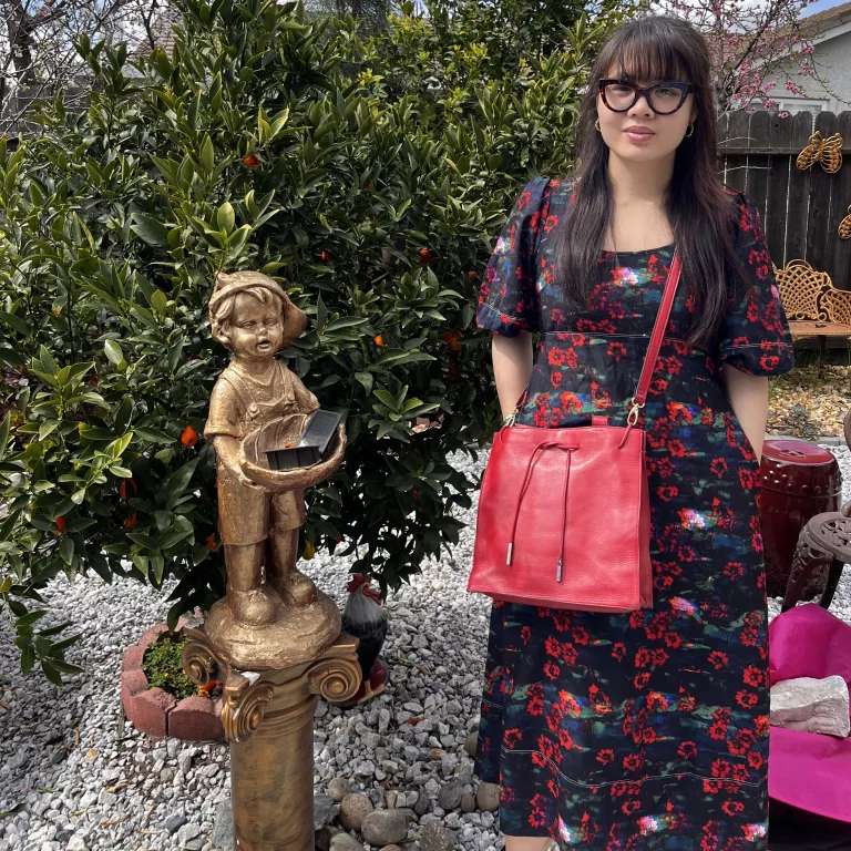 Woman in flower print maxi dress with red purse