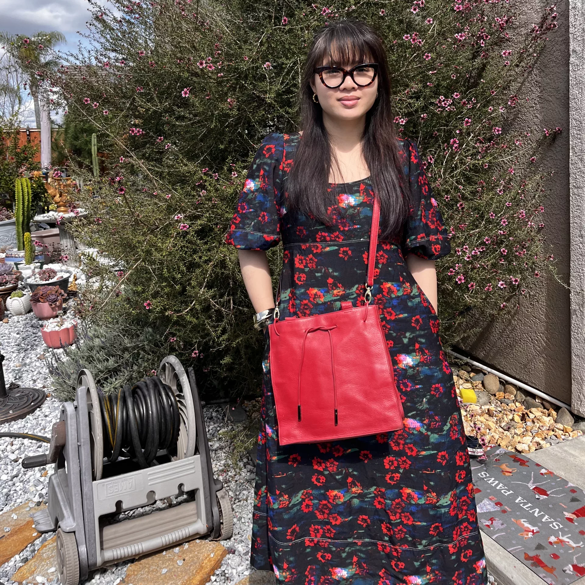 Woman with red purse in floral print maxi